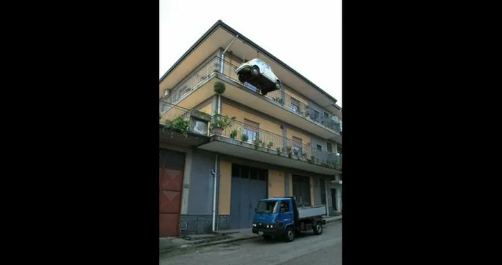 L’auto è senza assicurazione: per non farsela portare via, la appende fuori casa!