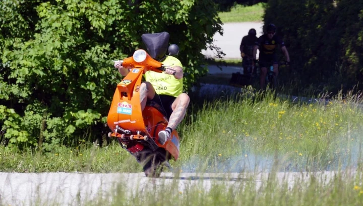 Va in impennata e da bendato in cima a una montagna con una Vespa