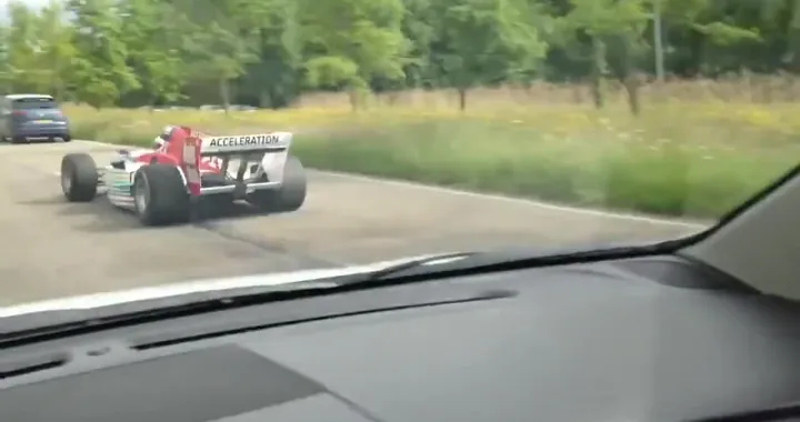 Una monoposto da Formula uno che sfreccia nel traffico