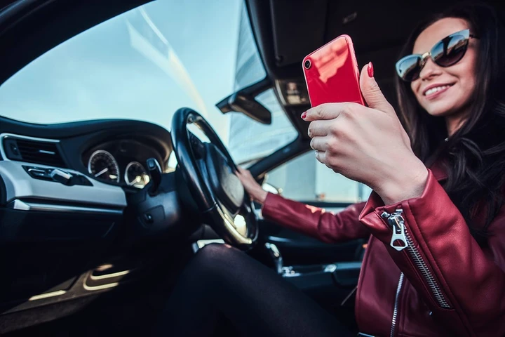 Mamma al volante con il cellulare in modalità selfie: multa per guida pericolosa
