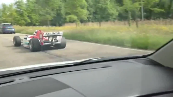 Una monoposto da Formula uno che sfreccia nel traffico